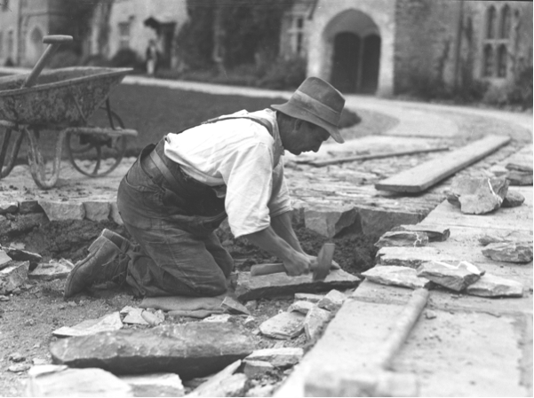 One of the estate workers laying the paving stones in the courtyard to Farrand’s design Photo: George Bennett, ©The Dartington Hall Trust Archive