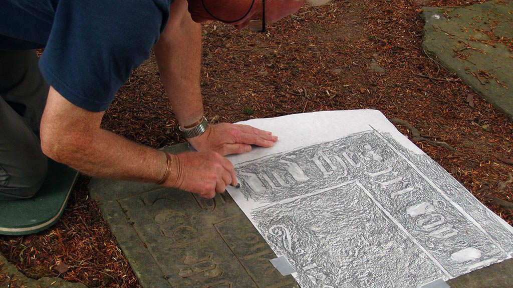 Volunteer Martin Broadbent carries out a gravestone rubbing as part of a project documenting the stones in St Mary's Old Churchyard.